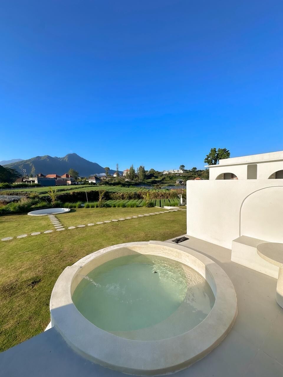 A circular hot tub with a clear view of a mountainous landscape in the background.