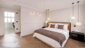 A bedroom with a large bed, bedside tables, and a view of a balcony. - Belgravia 4-bed House With Private Garden (London)