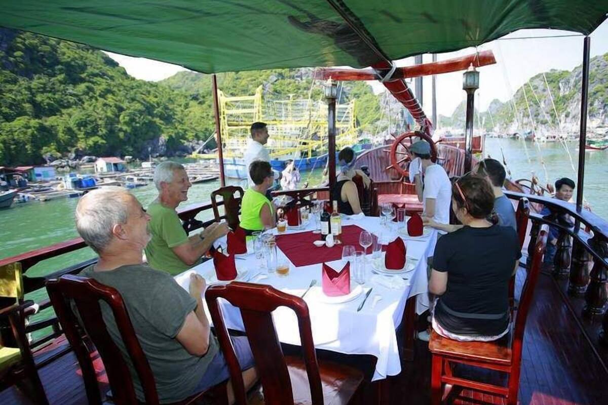 A dining area on a boat with tables set for a meal, surrounded by water and boats.