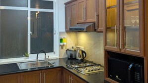 Una cocina con armarios de madera, estufa, lavaplatos y microondas.