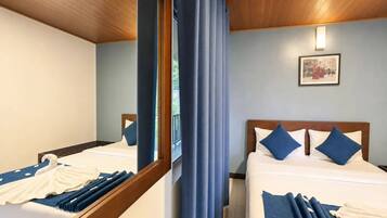 A hotel room with two beds, a large mirror, and a framed picture on the wall.