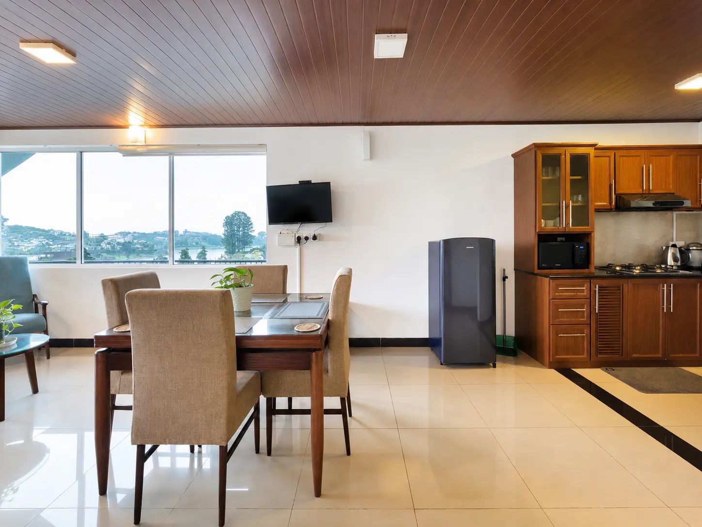 Une cuisine moderne avec des meubles en bois, un four à micro-ondes encastré et un grand réfrigérateur.