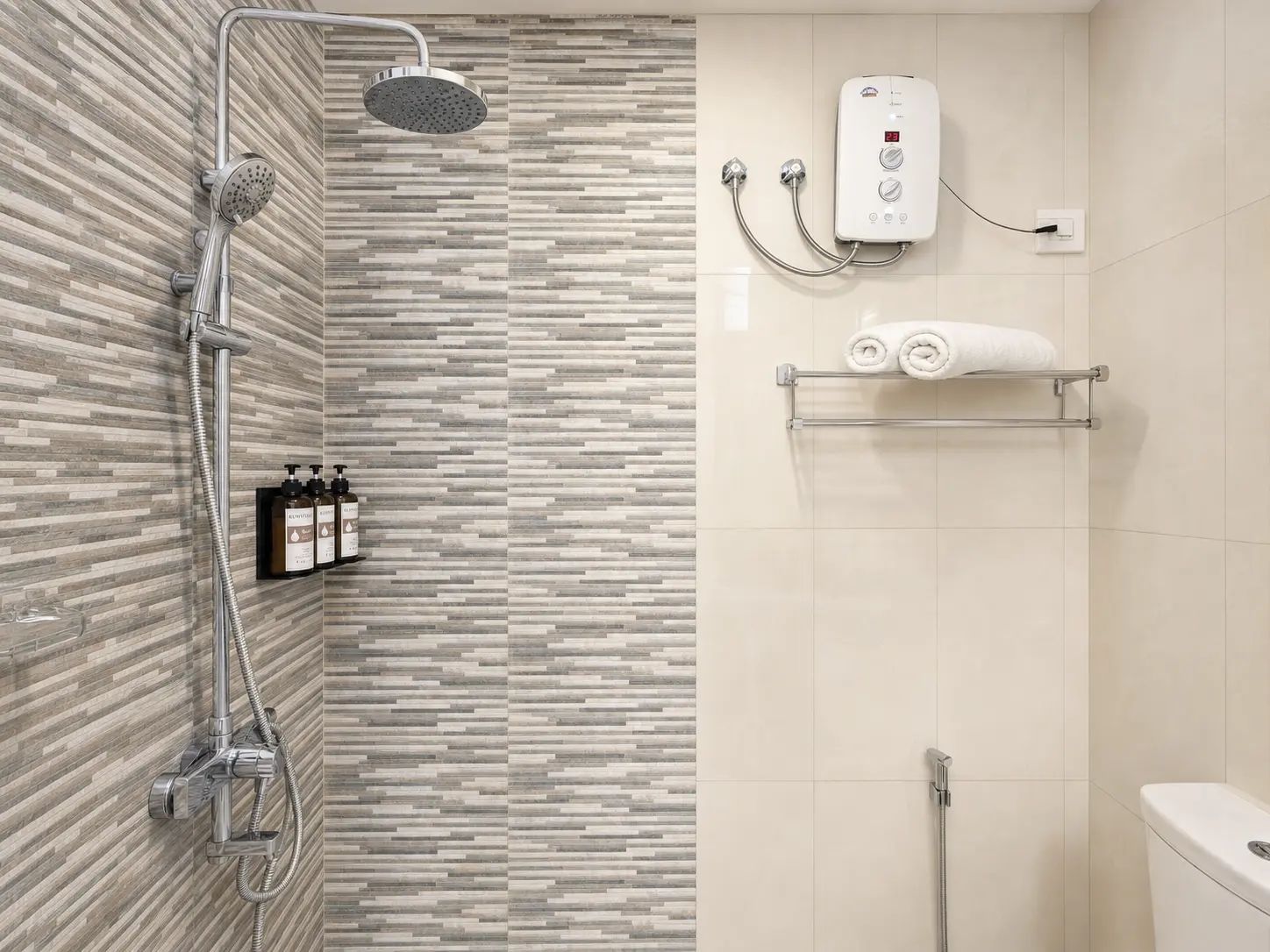 A modern bathroom with a shower, a toilet, and a towel rack.