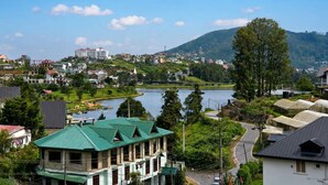 A residential area with a lake, houses with green roofs, and a hilly backdrop. - The Lakeside Stay (Nuwara Eliya)