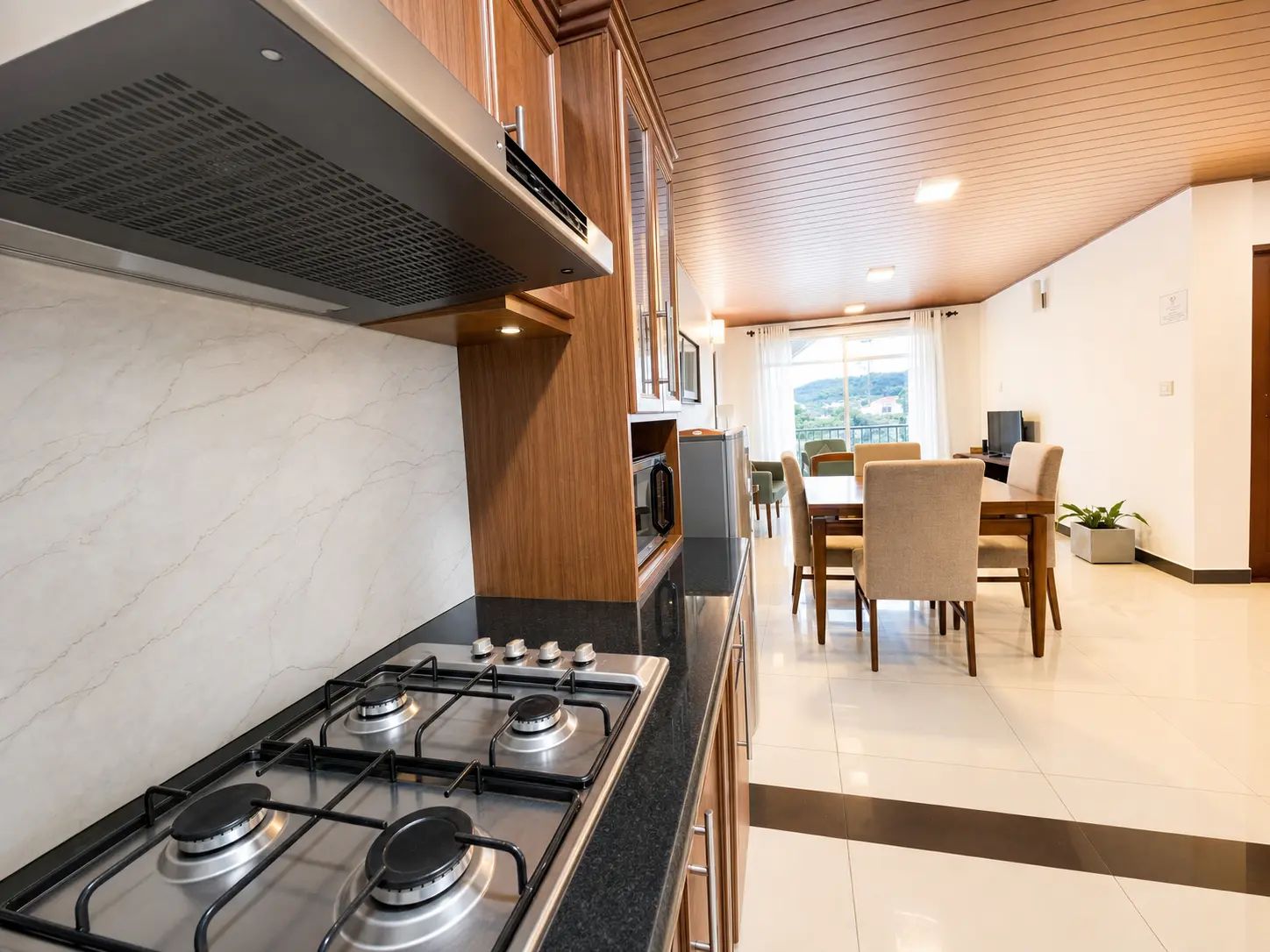 Una cocina moderna con estufa a gas, microondas y armarios de madera.