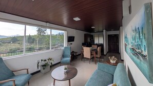 Un amplio salón con un gran ventanal, una mesa de comedor y un sofá.
