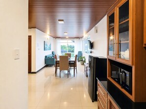 A modern kitchen with a built-in microwave and a wooden cabinet with glass doors. - The Lakeside Stay (Nuwara Eliya)