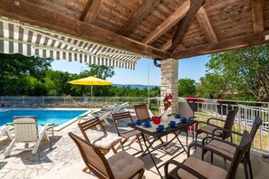 An outdoor patio with a pool, lounge chairs, and a table with blue cups. - Villa Ester - Private Pool Escape for 8, Labin, Croatia (Labin)