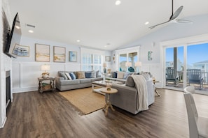 A spacious living room with a large sofa, a coffee table, and a fireplace. - Long Call - 5-bedroom retreat in Oak Island, perfect for families and pets! (Oak Island)