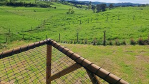 A fenced field with a clear sky and distant hills. - Cabaña chalet  con chimenea con wi-fi para nómadas digitales (Medellín)
