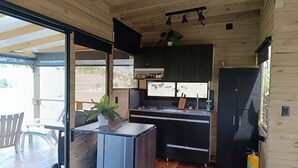 A modern kitchen with a large window, a built-in stove, and a refrigerator. - Cabaña chalet  con chimenea con wi-fi para nómadas digitales (Medellín)