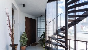 A modern interior with a staircase, potted plants, and a view of the outside. - The Still (Nam Nha Trang)