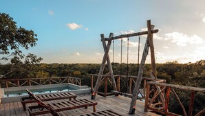 A wooden deck with lounge chairs and a pool.