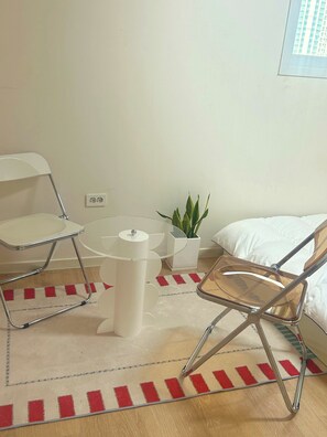 A small, modern room with a bed, a white desk, a chair, a small table, and a potted plant. - 해변가가 가깝다! K-바베큐가 가능한 4층 건물, 복층 스테이 (Ulsan)