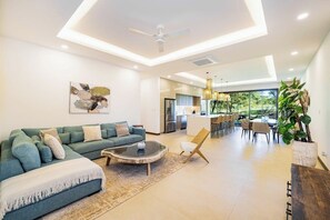Un salon moderne avec un canapé, une table basse et un coin repas.
