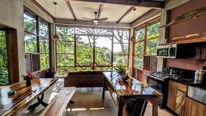 Una cocina amplia con ventanas grandes, un comedor y un ventilador de techo.