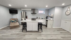 A modern kitchen with a central island, a built-in oven, and a microwave. - Newly renovated 2 bedroom basement with seperate entrance. (Whitby)