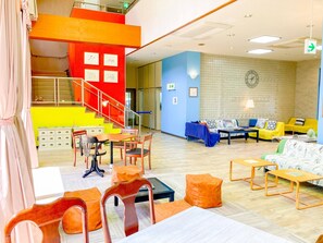 A hotel lobby with a staircase, seating area, and a clock on the wall. - Chiisana Hotel SHIMOKOSHIKI (Satsumasendai)