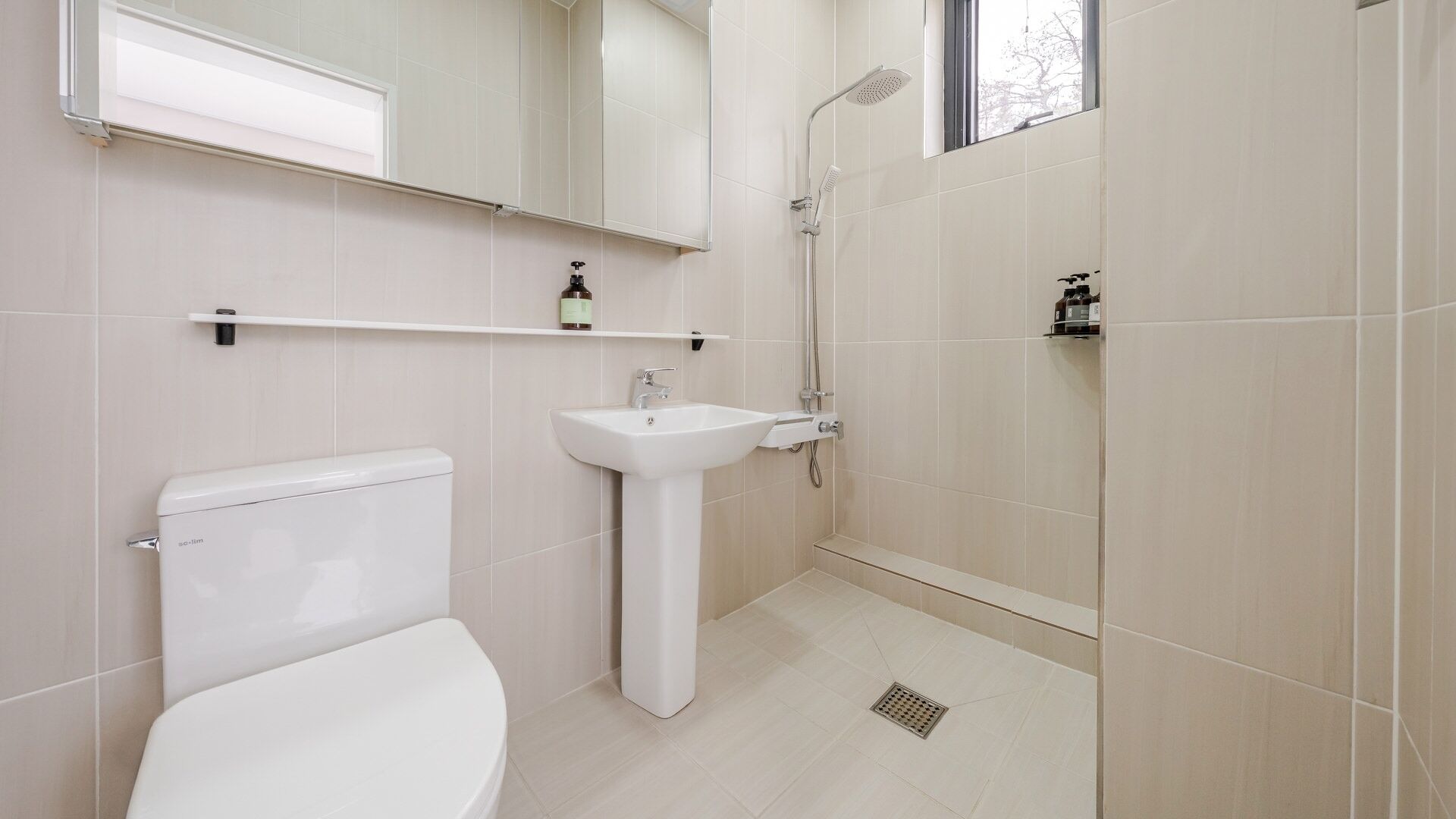 A bathroom with a toilet, sink, and shower.