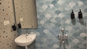 Une salle de bain avec un lavabo, un miroir et une douche.