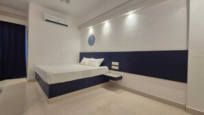 Une chambre d’hôtel moderne, équipée d’un lit, d’une table de chevet et d’un él ément décoratif mural.