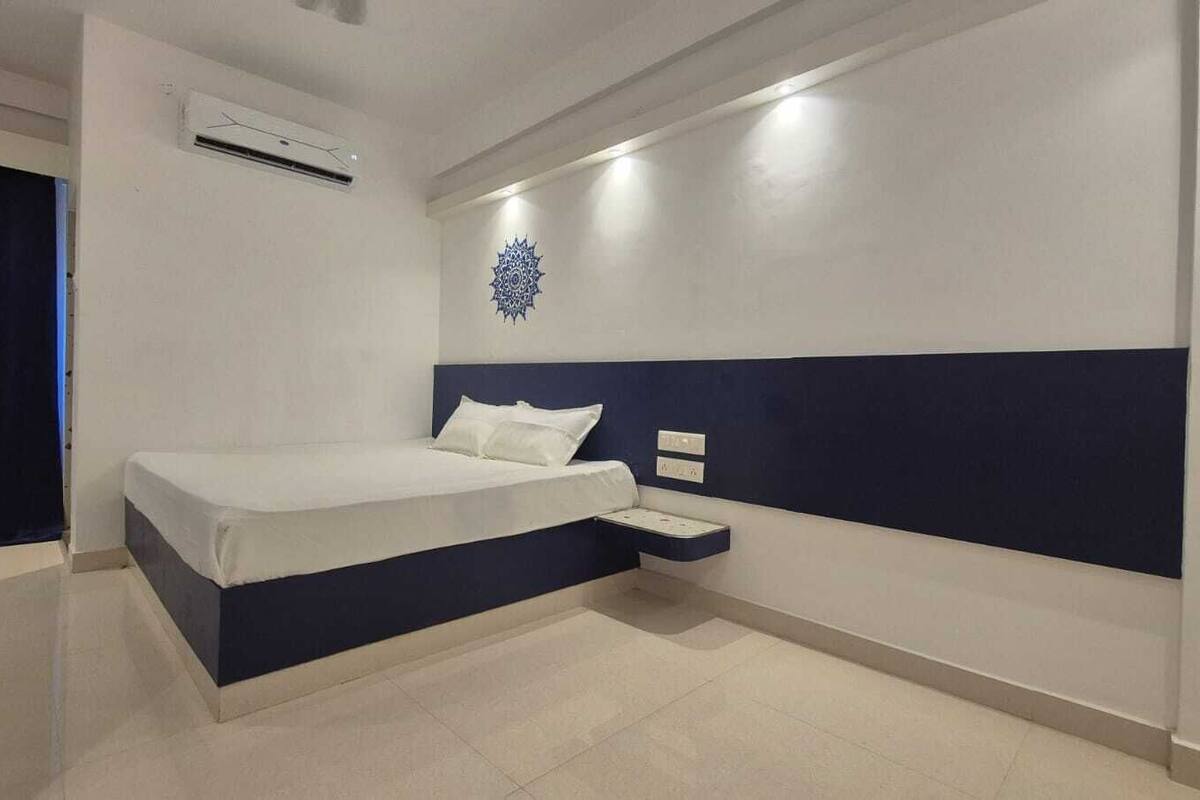 Ein modernes Hotelzimmer mit Bett, Nachttisch und einer Wanddekoration.