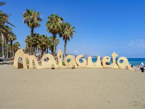 Ein Strand mit einer großen Sandskulptur, die ‚Malagueta‘ buchstabiert.