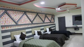 Ein Hotelzimmer mit einem gestreiften Kopfteil, einem Deckenventilator und einem flachbildfernseher an der Wand.