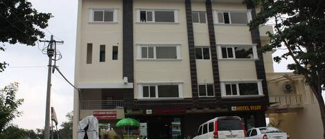 A multi-story hotel with a sign reading 'HOTEL VIJAY PARK.'