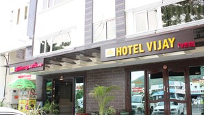 Ein Hotel namens 'Hotel Vijay' mit einem Schild, das anzeigt, dass es sich um ein vegetarisches Restaurant handelt.