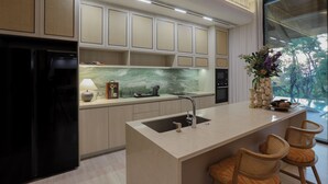 Una cocina moderna con isla integrada, un refrigerador y un lavamanos.