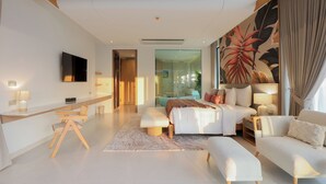 Una habitación de hotel moderna con cama, sofá, escritorio y televisor.
