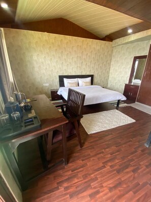 A bedroom with a bed, wooden desk, chair, and a dresser. - Stone Rose Vista (Tehri)