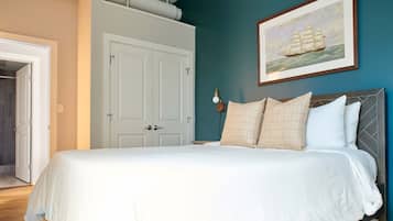 Un dormitorio con cama, una puerta y un cuadro colgado en la pared.