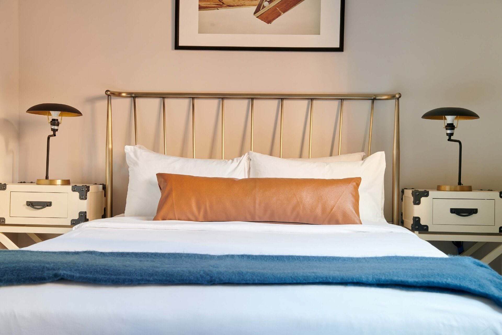 Un lit avec une tête de lit, deux tables de chevet et des lampes.