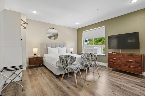 A bedroom with a bed, bedside tables, a TV, a dresser, and a window with a view. - Kasa LoHi Denver (Denver)