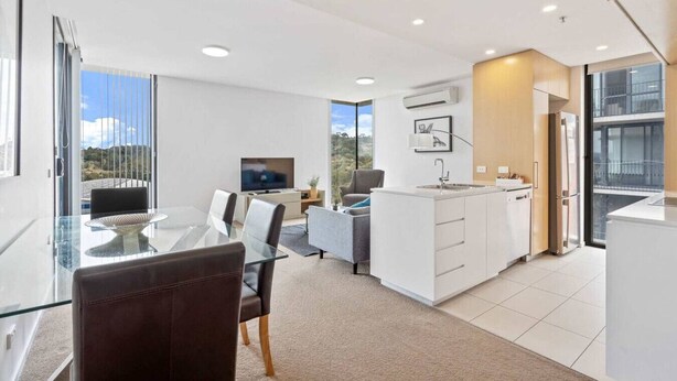 Un appartement moderne comprenant un coin repas, une cuisine et un espace de vie.