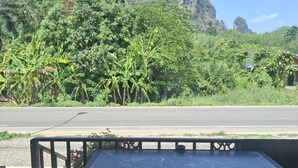 A table and chairs on a veranda with a view of a mountain and dense foliage. - Room-charming Ao Nang Guest Room 6 Bedro (Krabi)