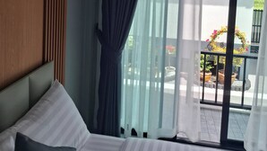 A hotel room with a bed, a window with curtains, and a view of the outside balcony. - Room-charming Ao Nang Guest Room 6 Bedro (Krabi)