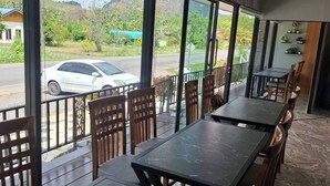 A restaurant with large windows, marble flooring, and wooden chairs. - Room-charming Ao Nang Guest Room 6 Bedro (Krabi)