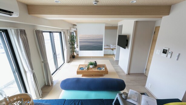 En moderne stue med sofa, sofabord og et maleri.