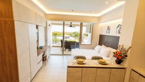 A modern hotel room with a bed, a dining area, and a view of the outdoors. - Azul infinite... apartasuit in beautiful Cartagena (Cartagena de Indias)