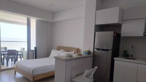 A modern bedroom with a bed, a small kitchenette, and a dining area with a table and chairs. - Azul infinite... apartasuit in beautiful Cartagena (Cartagena de Indias)
