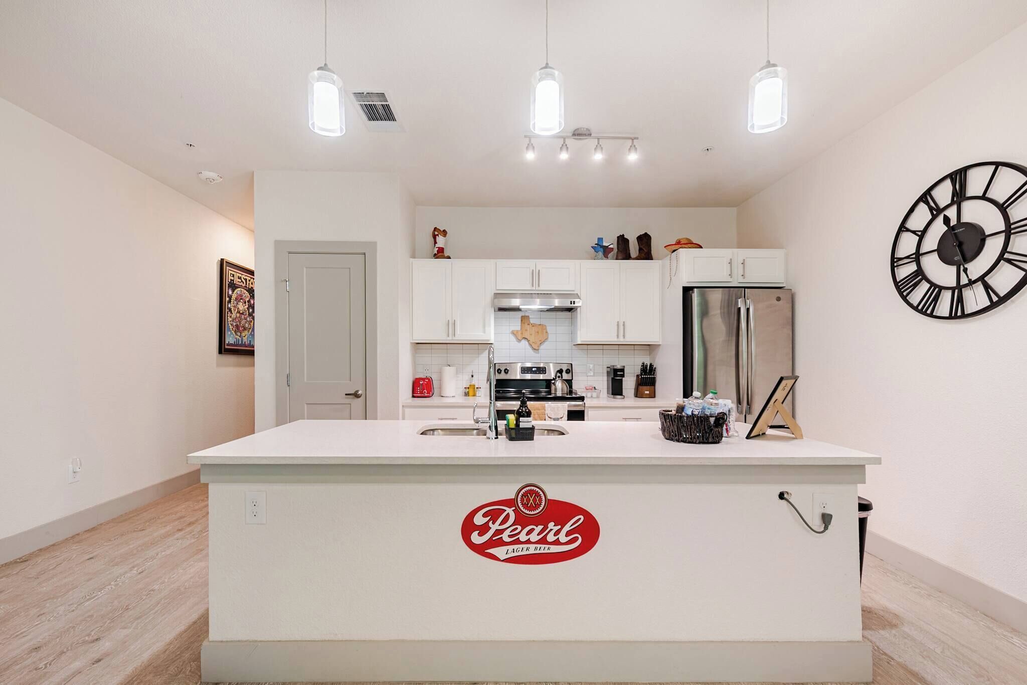 A modern kitchen with a central island, stainless steel appliances, and pendant lighting.