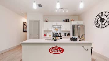 A modern kitchen with a central island, stainless steel appliances, and pendant lighting.