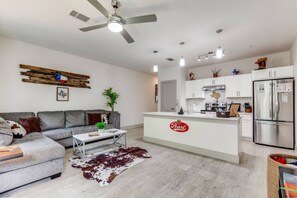 Un salon moderne comprenant un canapé, une table basse et un îlot central doté d’un réfrigérateur.