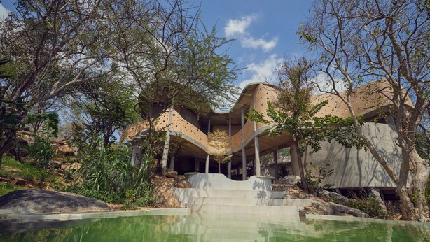 A modern building with a pool, surrounded by trees and rocks. - Winterfell by Sanctity Ferme Stays (Shoolagiri)
