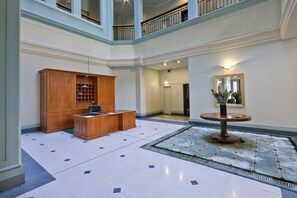 A spacious lobby with a reception desk, a wooden cabinet, a round table with a vase, and a mirror on the wall. - Location, Location, Loctation, AK CBD Harbour Edge (Auckland)