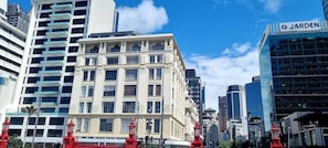 A cityscape with a mix of modern and classical architecture, including a prominent building with a sign that reads 'JARDEN.' - Location, Location, Loctation, AK CBD Harbour Edge (Auckland)