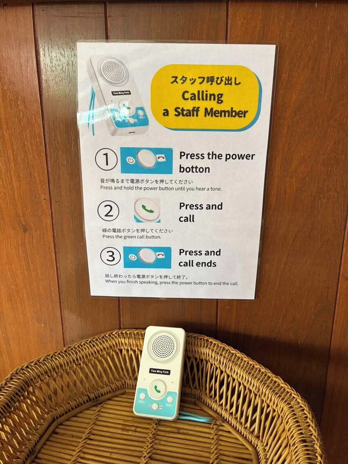 A two-way talk device on a wicker chair with instructions for calling a staff member.